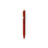 Dark red pen with gold clip and end cap. The tip is retracted, and the metal slide on the face-forward side indicates with a colored circle that the ink will be blue.