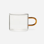 Low glass mug with a straight-sided clear bowl and a delicate, elongated, amber handle.