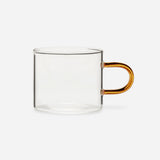 Low glass mug with a straight-sided clear bowl and a delicate, elongated, amber handle.
