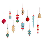Group of 12 Bauhaus Ornaments, each a different combination of stacked colorful shapes on a string. Colors include red, pale blue, red, magenta, green, and unpainted wood. Shapes include cones, cylinders, spheres, disks, and cubes.