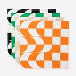 Four unfolded napkins with the same pattern, each in a different color-and-white colorway. Unfolded, the pattern is a 6x6 checker pattern, the left 4 columns fragment into offset half-moon shapes.