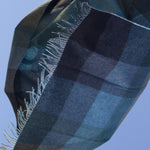 Checkered throw with fringe tips in an array of shades of green.