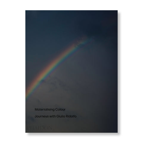 A book featuring a rainbow on its cover against a dark backdrop. There is black text printed on the bottom left corner of the book cover.
