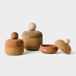 Display showing all three cork bolos on a white background with the smallest size opened to reveal cork interior.