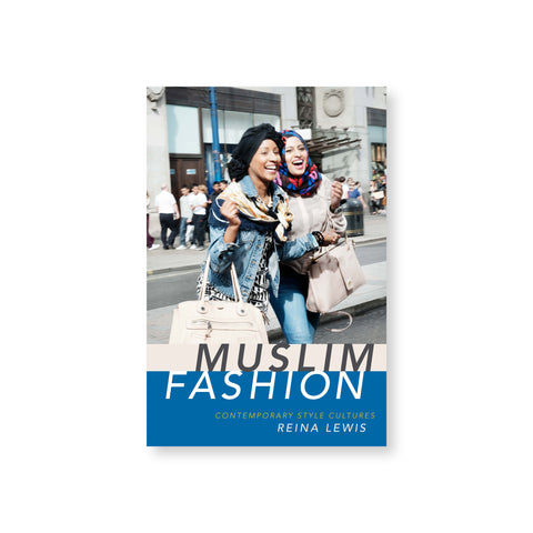 Muslim Fashion book cover featuring a photograph of two women wearing denim and carrying large purses, one wearing a turban and one wearing a hijab, laughing as they crossing a street. Title in a blue band across the bottom of the cover.