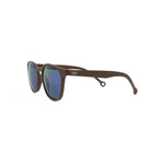 Side angle view of the Ruta Sunglasses Brown/Blue, which have brown, rounded square-rectangular frames, and blue lenses. The Parafina logo, two line waves, is printed in silver on the temple of the right arm.