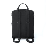 Back view of a black medium sized backpack featuring adjustable carrying straps and a leather top handle