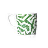 White coffee mug with a green printed zig zag pattern.