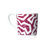 White coffee mug with a maroon printed zig zag pattern.