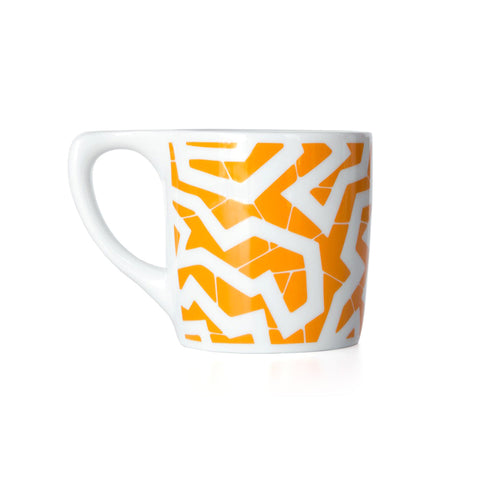 White coffee mug with a yellow-orange printed zig zag pattern.